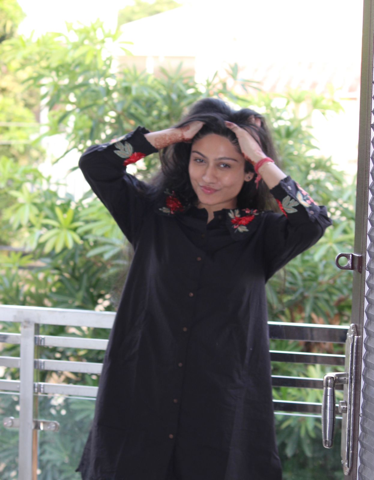 Woman wearing a black outfit with floral patterns outdoors